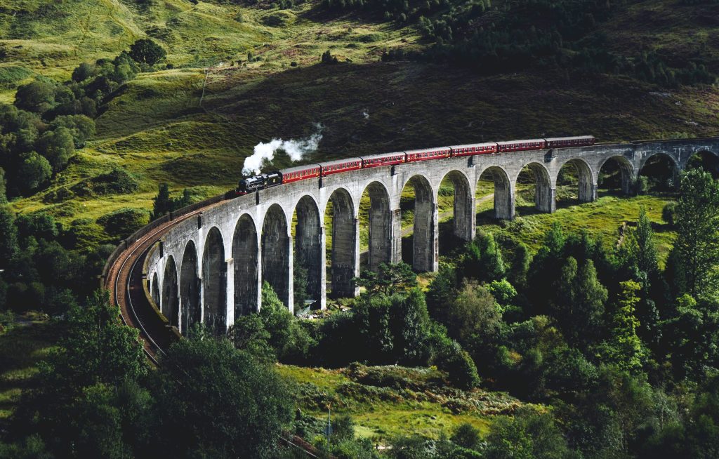 El viaducto de Glenfinnan en Escocia, con el tren Jacobite Steam Train cruzándolo, la icónica localización utilizada para las escenas del Expreso de Hogwarts en Harry Potter.